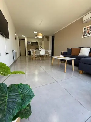 a living room with a couch and a table at Departamento premium con amplio patio en pleno centro de Carlos Paz in Villa Carlos Paz