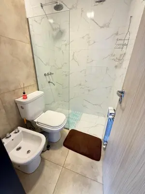 a bathroom with a toilet and a glass shower at Departamento premium con amplio patio en pleno centro de Carlos Paz in Villa Carlos Paz
