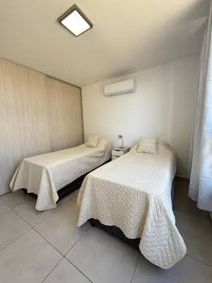 two beds in a small room with white sheets at Departamento premium con amplio patio en pleno centro de Carlos Paz in Villa Carlos Paz