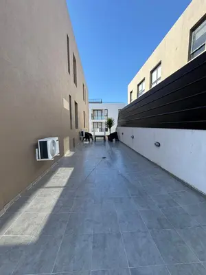 a walkway between two buildings with a tv on the side at Departamento premium con amplio patio en pleno centro de Carlos Paz in Villa Carlos Paz
