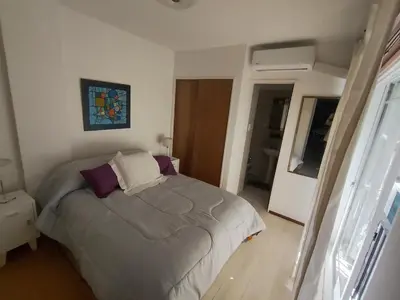 a bedroom with a bed with purple and white pillows at I rent an apartment in the center of Cordoba Capital in Cordoba