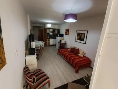 a living room with a red couch and a table at I rent an apartment in the center of Cordoba Capital in Cordoba