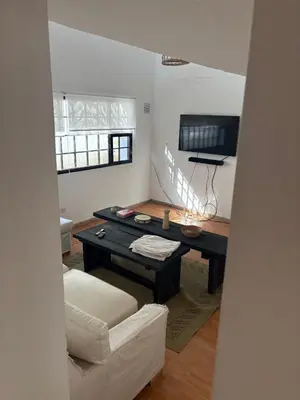 a living room with a table and a couch at Casa Guemes, pet friendly in Villa Carlos Paz