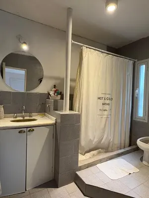 a bathroom with a shower curtain and a toilet at Casa Guemes, pet friendly in Villa Carlos Paz