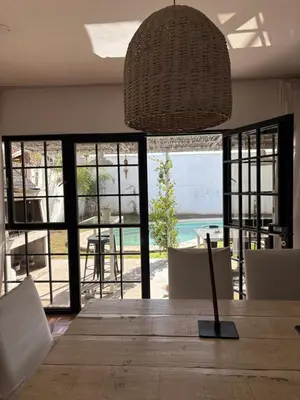 a dining room with a table and chairs and a light fixture at Casa Guemes, pet friendly in Villa Carlos Paz