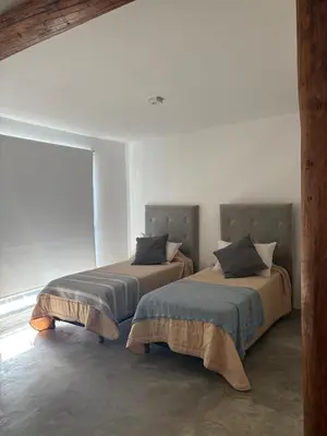 two beds sitting next to each other in a room at Casa Guemes, pet friendly in Villa Carlos Paz