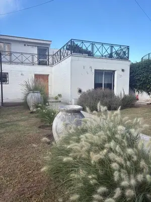 a white building with a balcony on top of it at Casa Guemes, pet friendly in Villa Carlos Paz