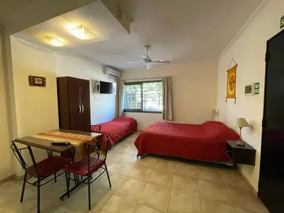 a bedroom with two beds and a table and chairs at Complejo Don H in Villa Carlos Paz