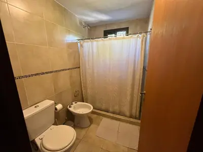 a small bathroom with a toilet and a shower at Complejo Don H in Villa Carlos Paz