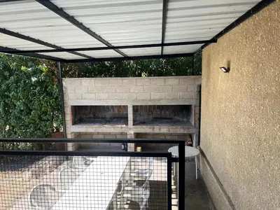 a patio with a brick fireplace and a table at Complejo Don H in Villa Carlos Paz