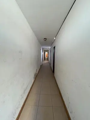 an empty hallway with a long corridor at Apart Geranio, monoambiente en planta baja in Río Cuarto