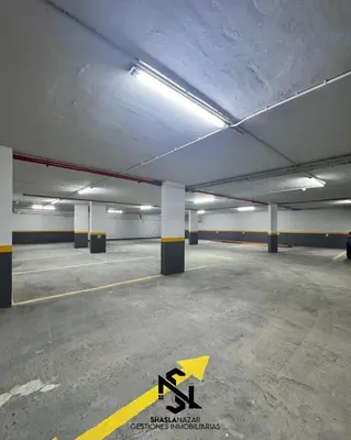 an empty parking garage with a yellow arrow on the ground at departamento en edificio torre libertador in Río Tercero