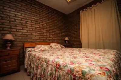 a bedroom with a bed and a brick wall at Nélida Dpto 1 in Villa Carlos Paz