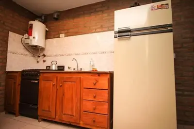 a kitchen with a white refrigerator and a stove at Nélida Dpto 1 in Villa Carlos Paz