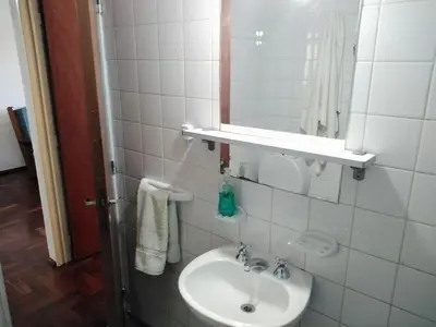 a white bathroom with a sink and a mirror at Departamento en zona centro La Cañada para 2 personas in Cordoba