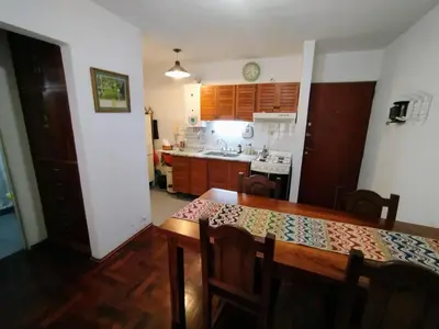 a kitchen with a wooden table and a dining room at Departamento en zona centro La Cañada para 2 personas in Cordoba