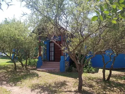 a blue house with trees in front of it at Abrazo del Sol in Villa Santa Cruz del Lago