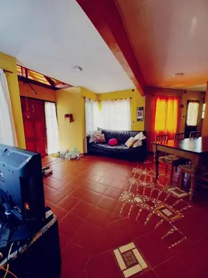 a living room with a couch and a television at Abrazo del Sol in Villa Santa Cruz del Lago