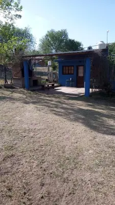 a blue house with a picnic table in front of it at Abrazo del Sol in Villa Santa Cruz del Lago