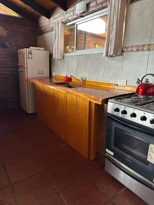 a kitchen with a stove and a refrigerator at Ludqui in Villa Rumipal