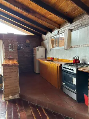 a kitchen with a stove and a refrigerator at Ludqui in Villa Rumipal