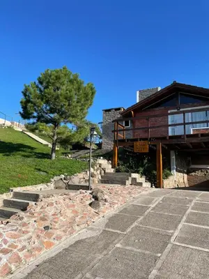 a building with a tree and stairs in front of it at Ludqui in Villa Rumipal