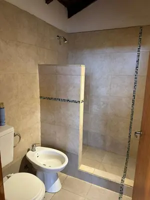a bathroom with a shower with a toilet and a sink at Ludqui in Villa Rumipal