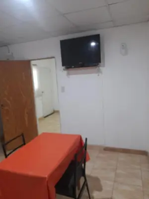 a room with a table and a flat screen tv on the ceiling at Alquiler de departamento por dia in Río Cuarto