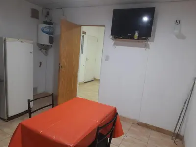 a room with a table and a tv on a wall at Alquiler de departamento por dia in Río Cuarto