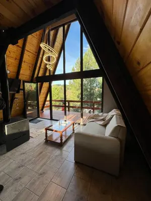 a living room with a couch and a large window at Aire Escondido in Villa Berna