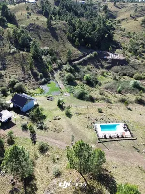 an aerial view of a house and a swimming pool on a hill at Aire Escondido in Villa Berna