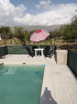 a table with an umbrella next to a pool at Hospedaje Miraflor in Cerro de Oro
