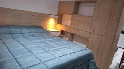 a bedroom with a blue bed and a desk at Miralejos 16 Turquesa in Villa Carlos Paz