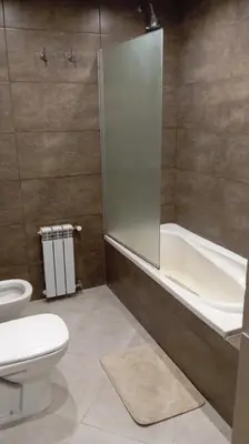 a bathroom with a shower and a toilet and a tub at Dpto Premium Costanera Pileta y Cochera in Villa Carlos Paz