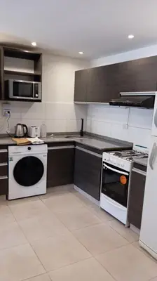 a kitchen with a stove and a microwave at Dpto Premium Costanera Pileta y Cochera in Villa Carlos Paz