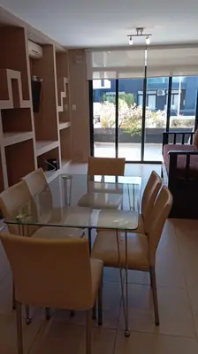 a dining room with a glass table and chairs at Dpto Premium Costanera Pileta y Cochera in Villa Carlos Paz