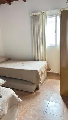 two beds in a room with a window at Departamento Carlos Paz cerca Centro y Río in Villa Carlos Paz