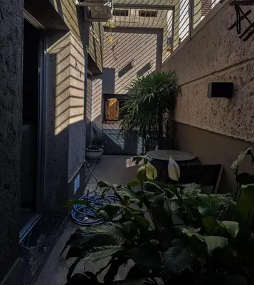 a courtyard with plants and a building with a window at Modern PH with Grill in Cordoba
