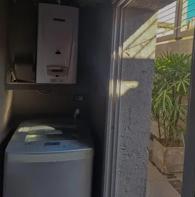 a small bathroom with a trash can and a washing machine at Modern PH with Grill in Cordoba