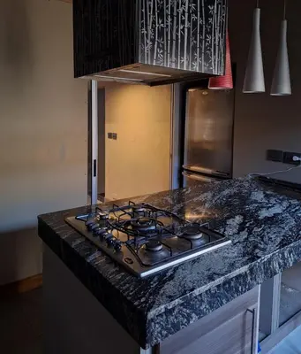 a stove top in a kitchen with a counter top at Modern PH with Grill in Cordoba