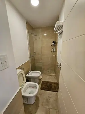 a bathroom with two toilets and a sink and a shower at Hermoso Departamento tipo Duplex en piso 17y18 in Cordoba