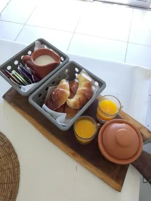a tray of food with pastries and orange juice at Tiny House Potrero Cba in Potrero de Garay