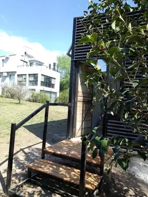 a wooden bench sitting next to a building at Tiny House Potrero Cba in Potrero de Garay