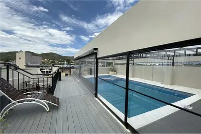 a balcony with a swimming pool on top of a building at Departamento Céntrico Miralejos 3 in Villa Carlos Paz