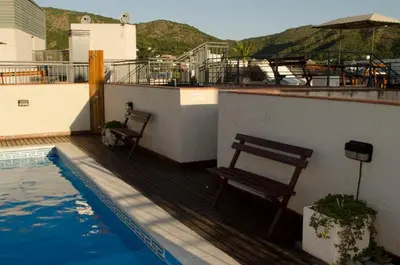 a balcony with two benches and a swimming pool at Departamento Céntrico Miralejos 3 in Villa Carlos Paz