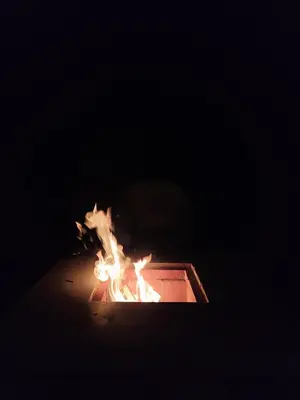 a fire in a box in the dark at Brisas de la Cayana Cabaña Villa Alpina in Villa Alpina