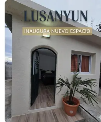 a building with a door and a plant in front at Lusanyun in Villa Carlos Paz