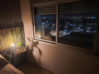 a window with a view of a city at night at Terra Zion in Cordoba