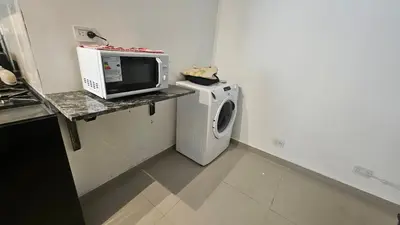 a microwave and a washing machine in a kitchen at Semipiso CALAZANS in Cordoba