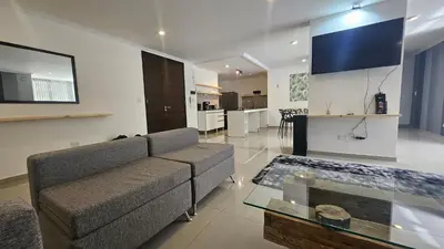 a large living room with a couch and a kitchen at Semipiso CALAZANS in Cordoba